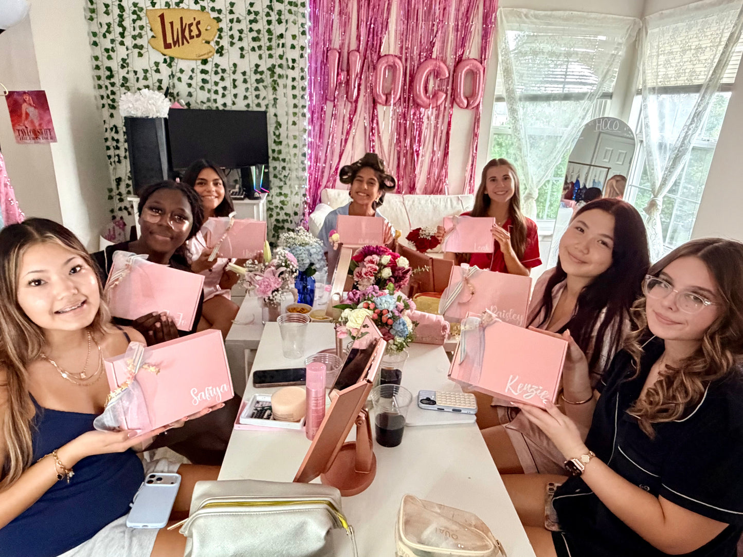 Friends holding Ivy & Bugz personalized HOCO gift boxes while getting ready for homecoming