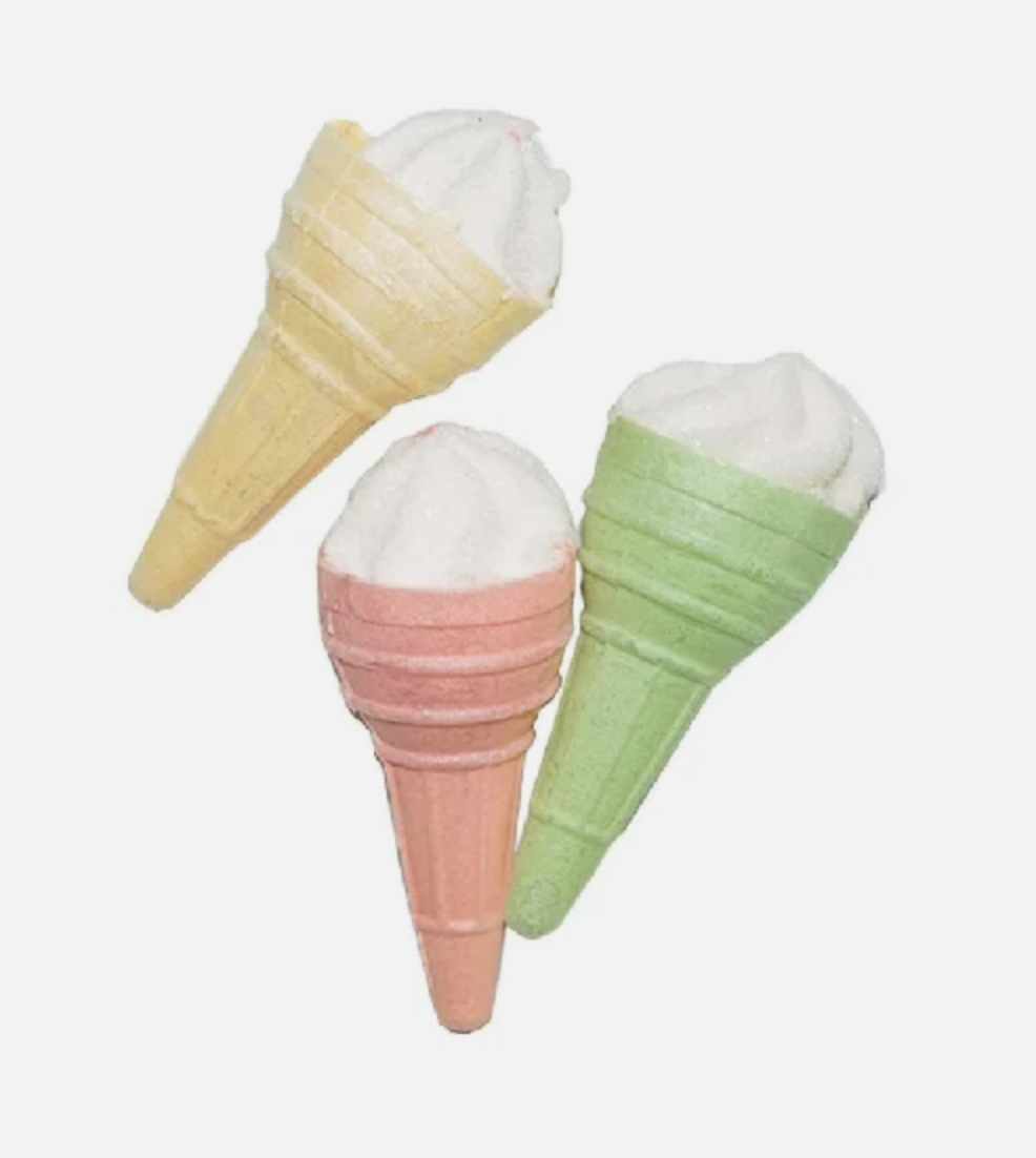 Three ice cream cone-shaped candies in pastel colors on a white background