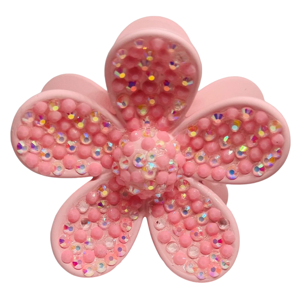 Pink flower-shaped object with glittery beads on a white background