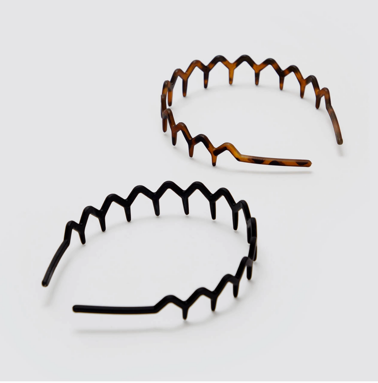 Two tortoiseshell headbands on a light gray background