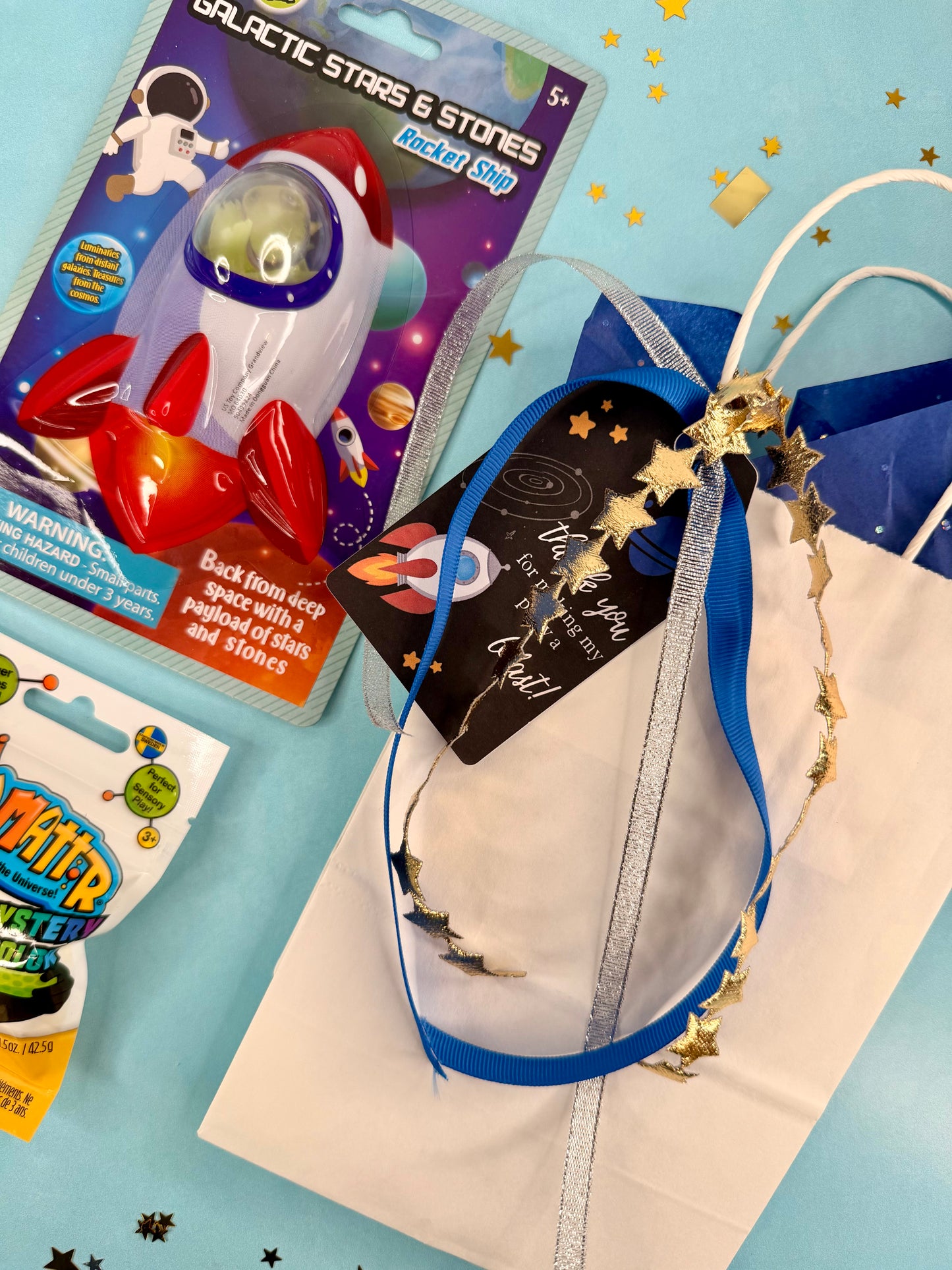 Space-themed toys and accessories on a blue background with stars.