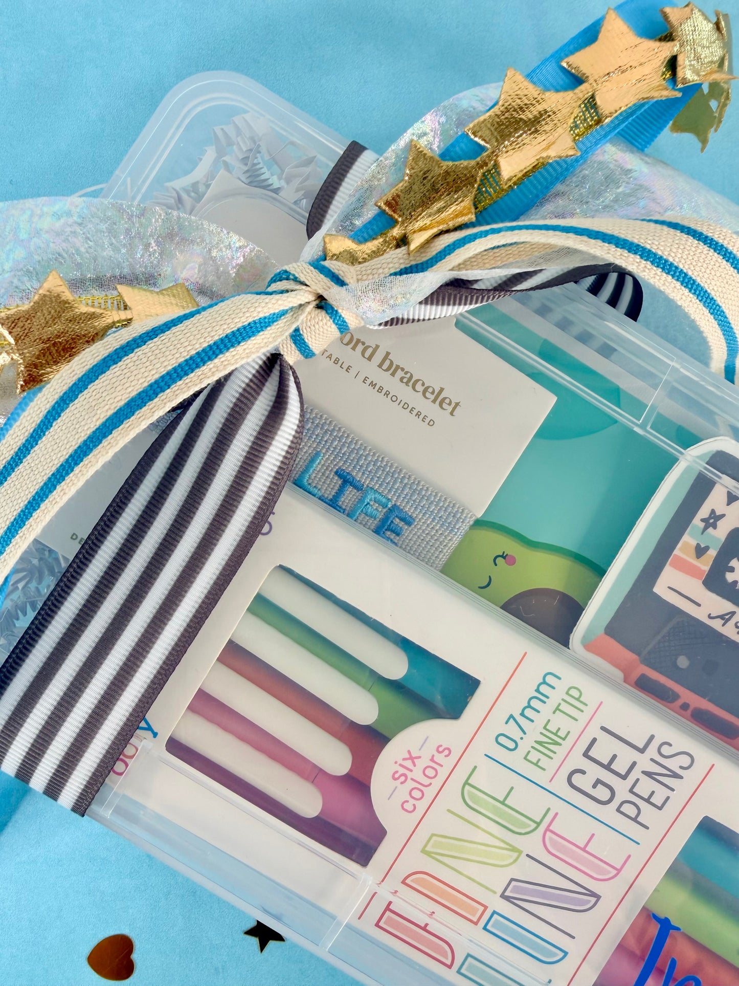 Packaging of gel pens with decorative ribbons and stars on a blue background