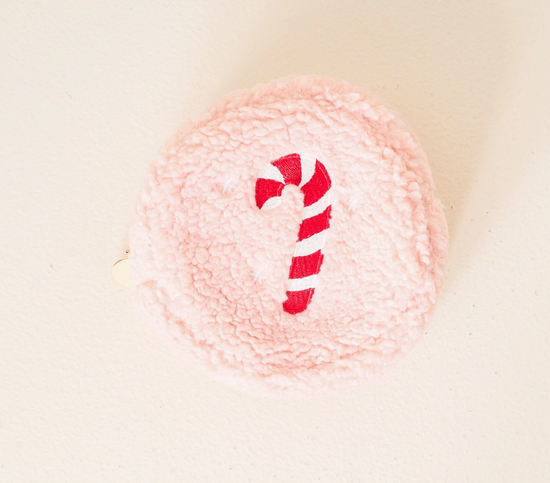 Pink yarn ball with a candy cane design on a light beige background