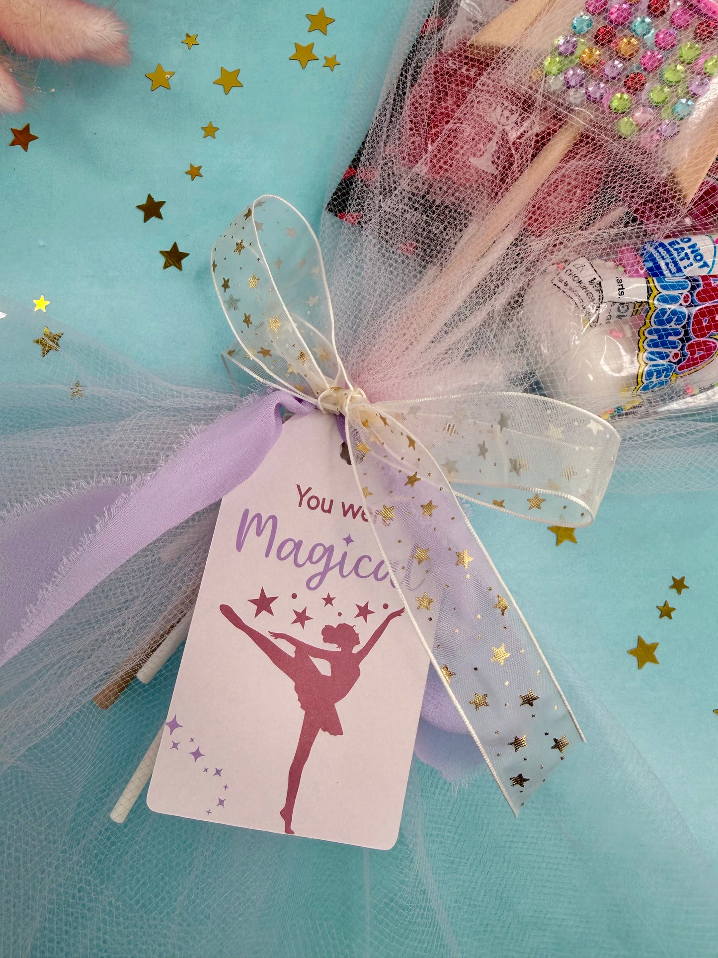 Ballerina-themed gift with tulle, ribbons, and a 'You will be magical' tag on a turquoise background.