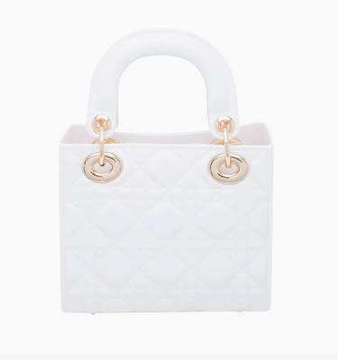 White handbag with gold handles on a white background