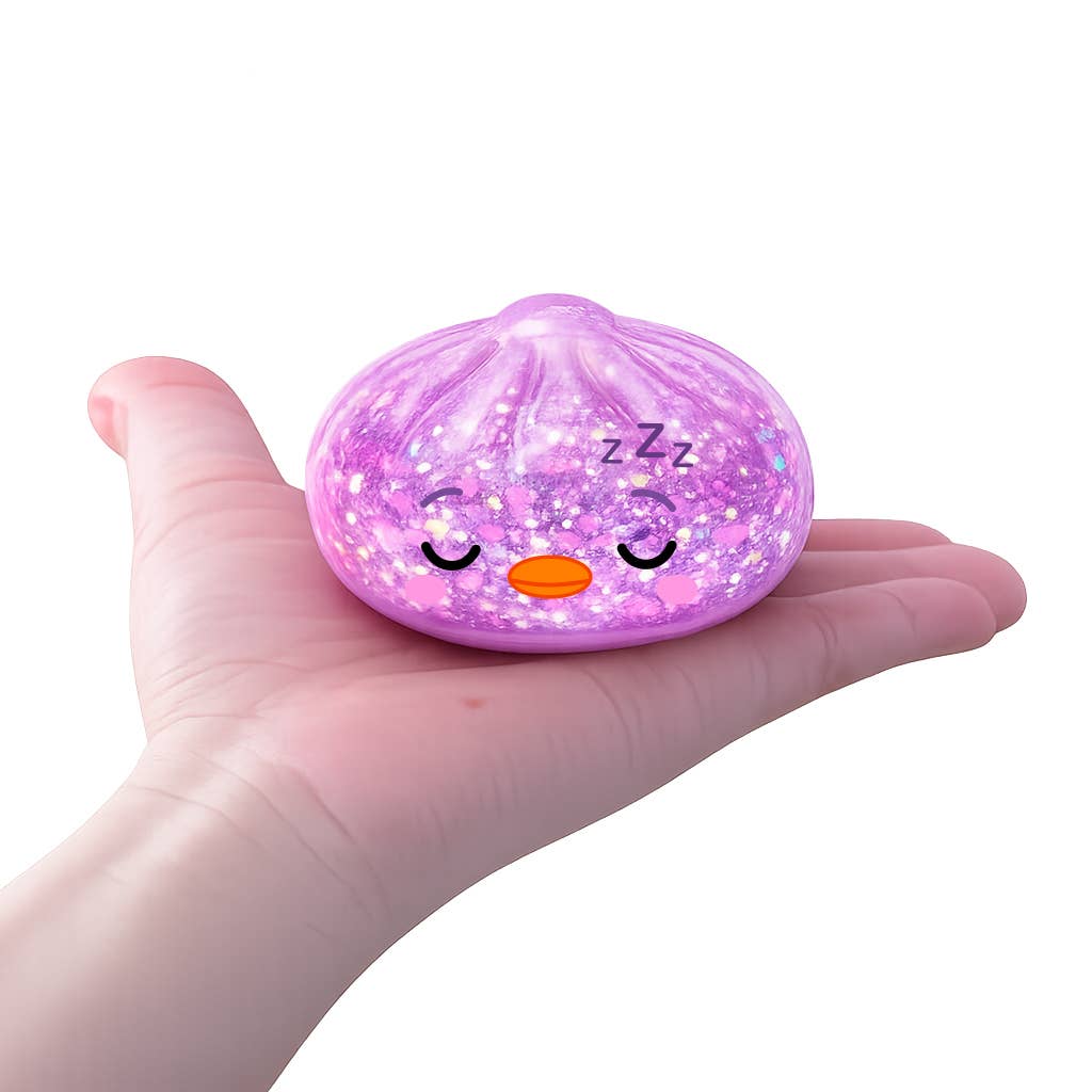 Pink glittery stress ball with a face on a hand against a white background