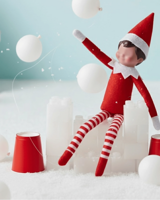 Elf on the Shelf in a festive setting with balloons and snow, branded 'Ellie's Party Supply'.