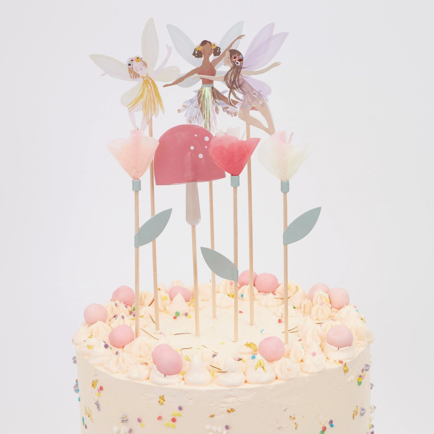 Decorative cake with fairy toppers on a white background