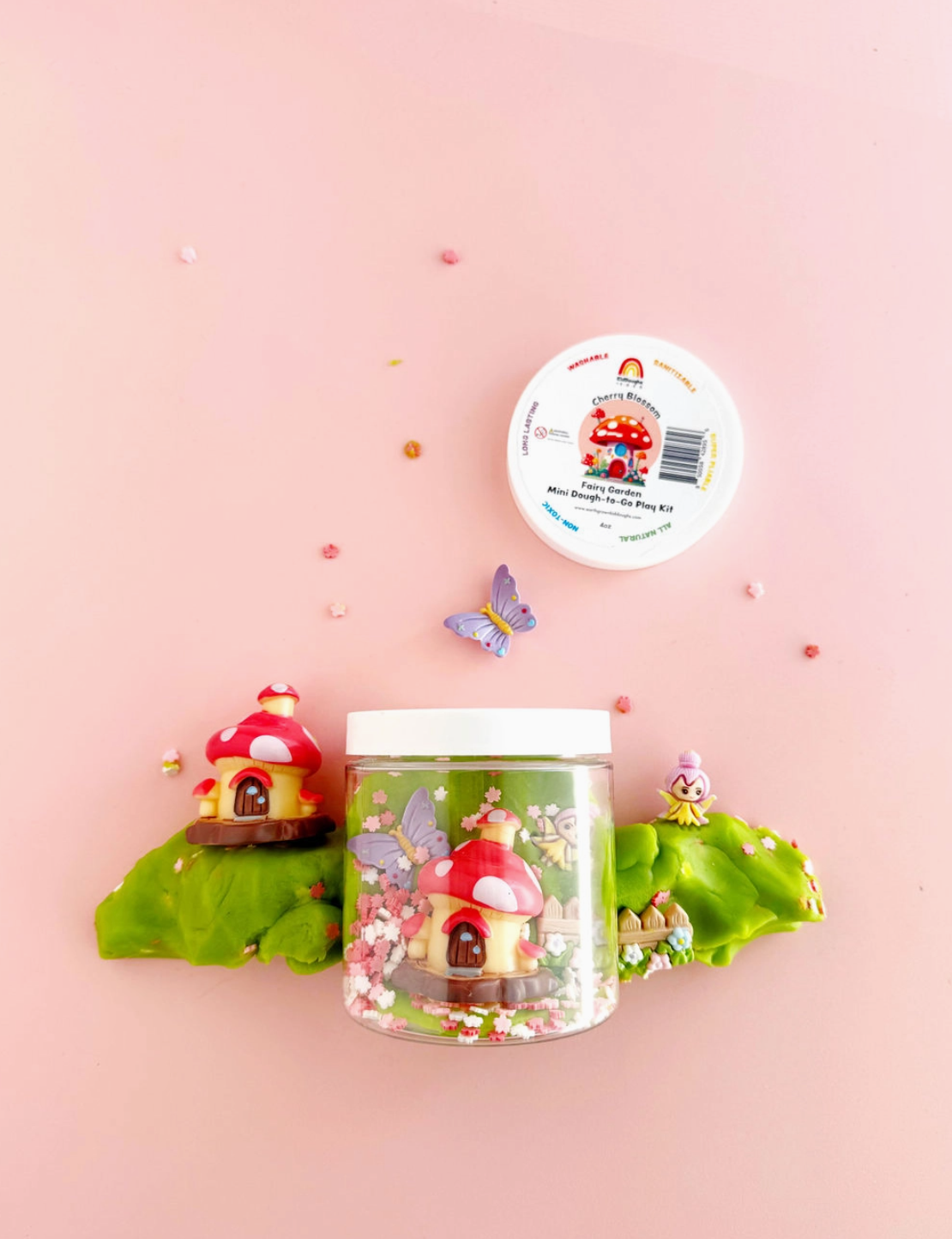 Decorative jar with fairy house design on a pink background