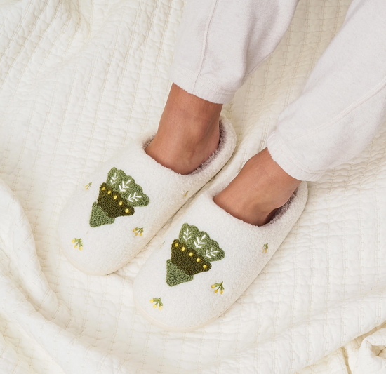 White slippers with green tree designs on a white background