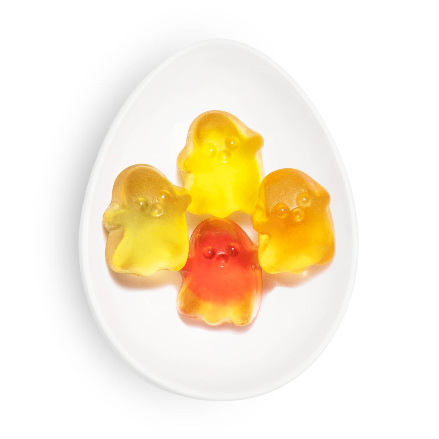 Four colorful gummy bears on a white plate