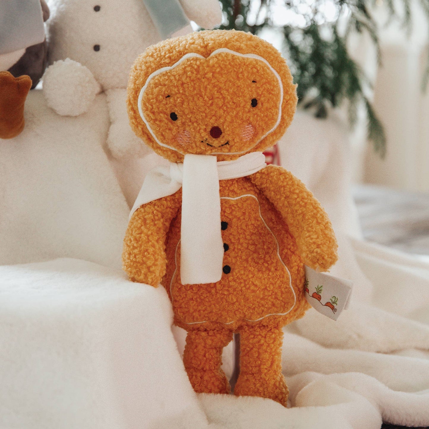 Gingerbread man plush toy on a white surface with a blurred background