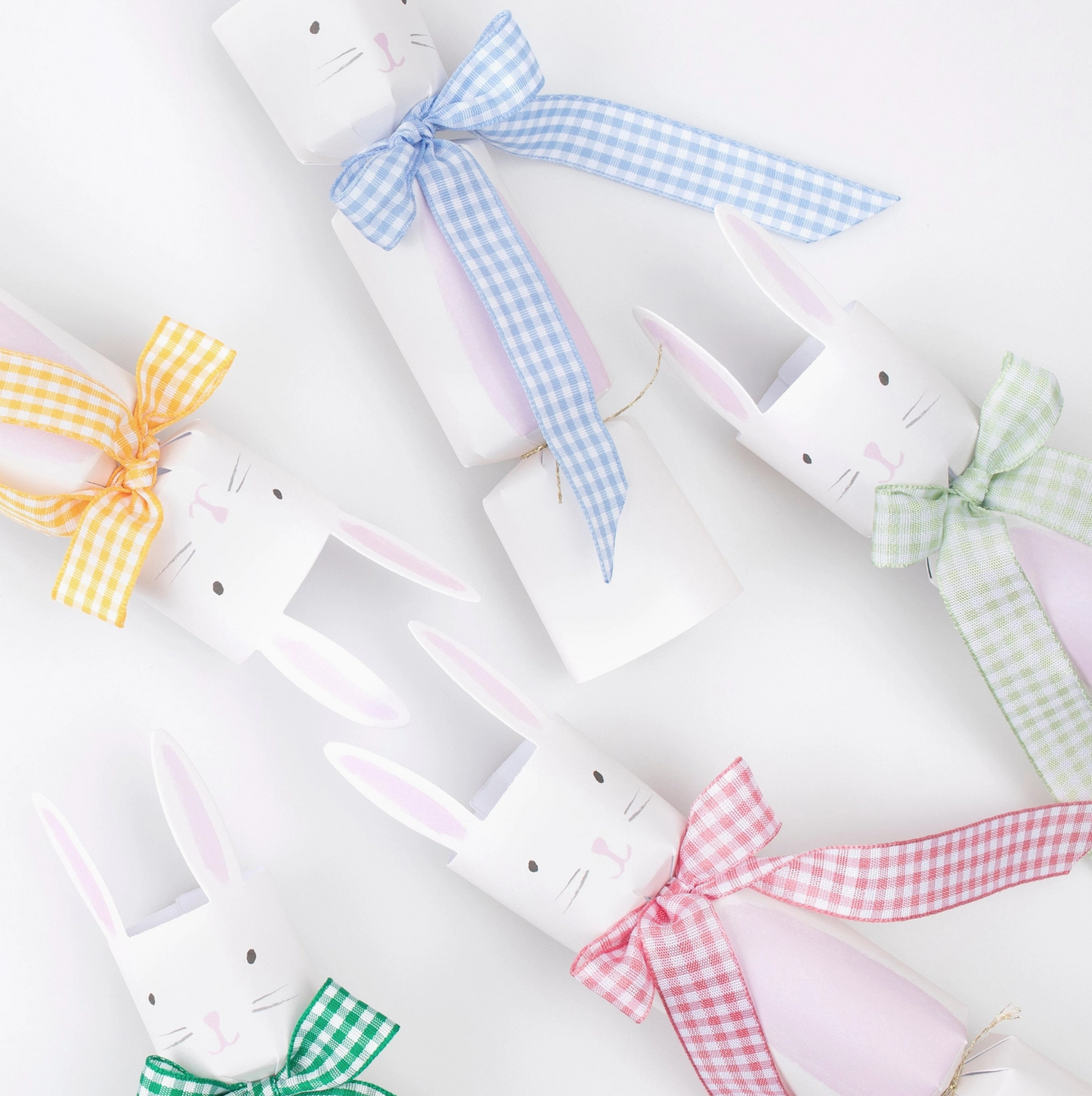 White bunny-shaped boxes with colorful checkered ribbons on a white background