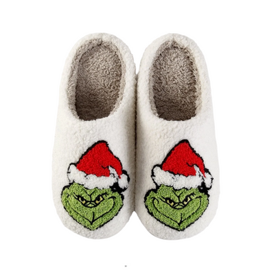 A pair of white fuzzy slippers with a Christmas themed design featuring the character 'The Grinch' with a Santa hat and a green nose.