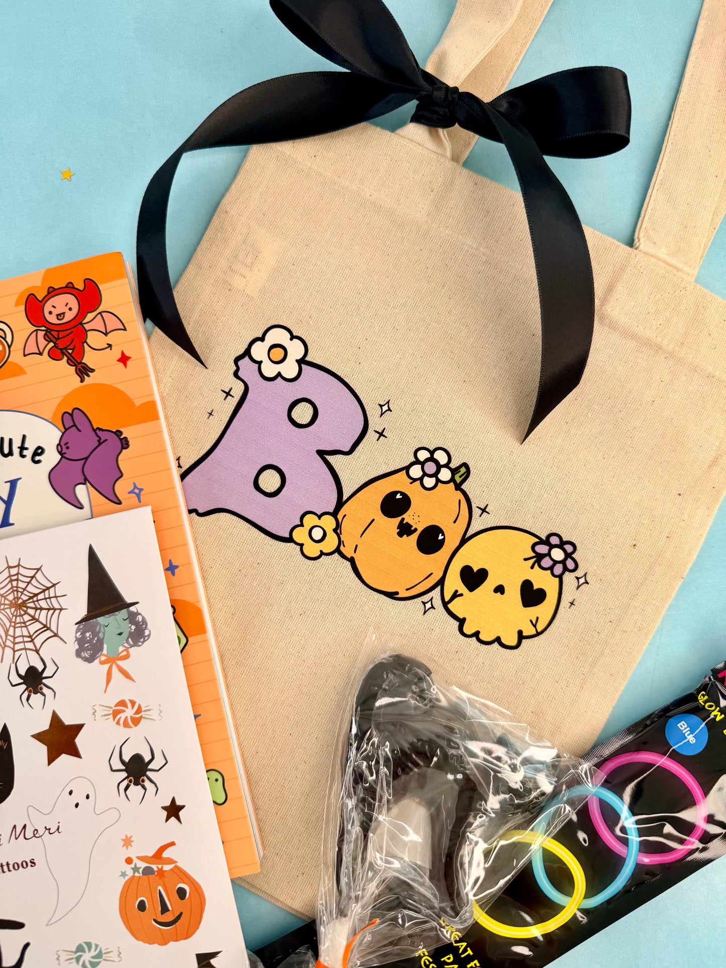 Cute Halloween boo bag for kids with a spooky drawing book, temporary tattoos, glow bracelets, ghost lollipop, and canvas ghost bags