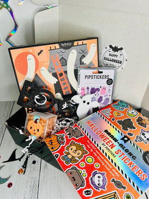 Halloween-themed items including stickers and a card on a white surface.