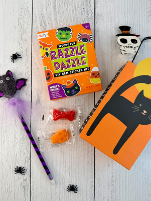 Set of Halloween party favors with gem sticker kits, gummy candy, pencils, and black cat favor boxes.