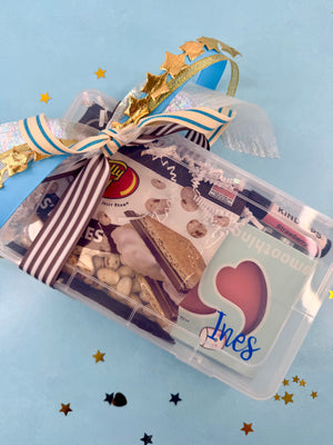 Clear plastic packaging with snacks and a heart-shaped item on a blue background