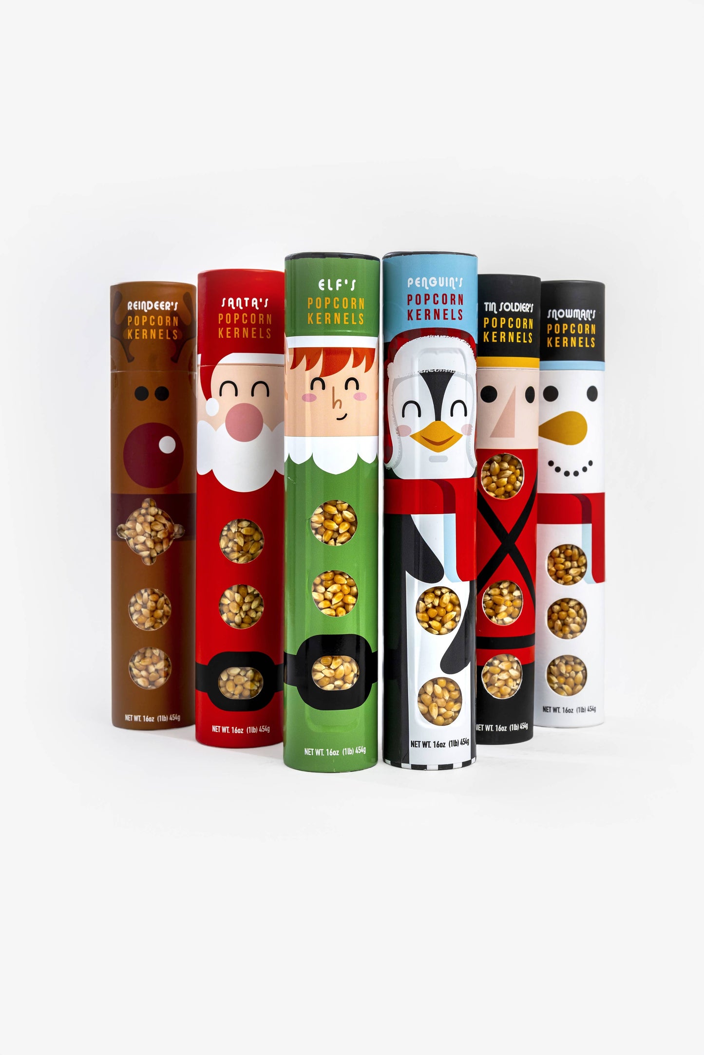 Six novelty popcorn kernels in cylindrical packaging, each designed as a different holiday character: Rudolph the Red-Nosed Reindeer, Santa Claus, Elf, Tinker Bell, Peter Pan, and Snowman. The packages are arranged in a row against a clean white background.