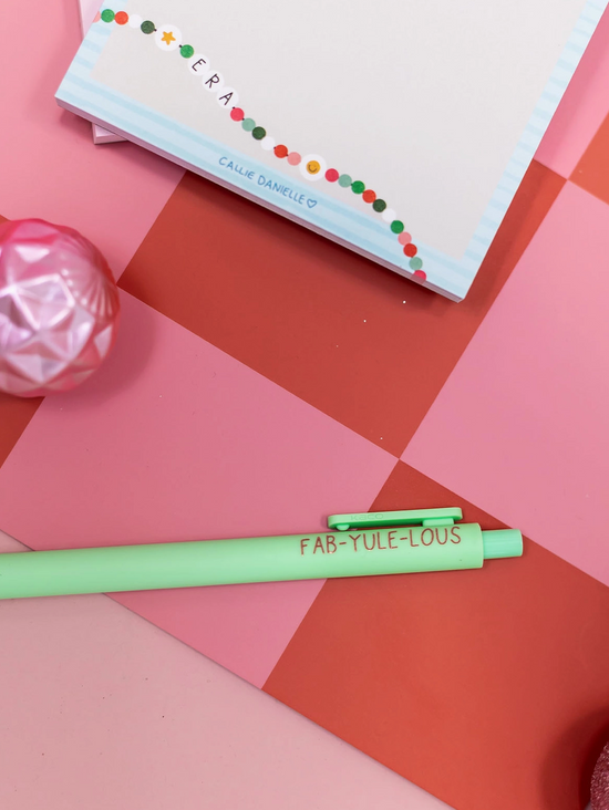 Green pen with 'FAB-YULE-IOUS' text on a pink and orange geometric background