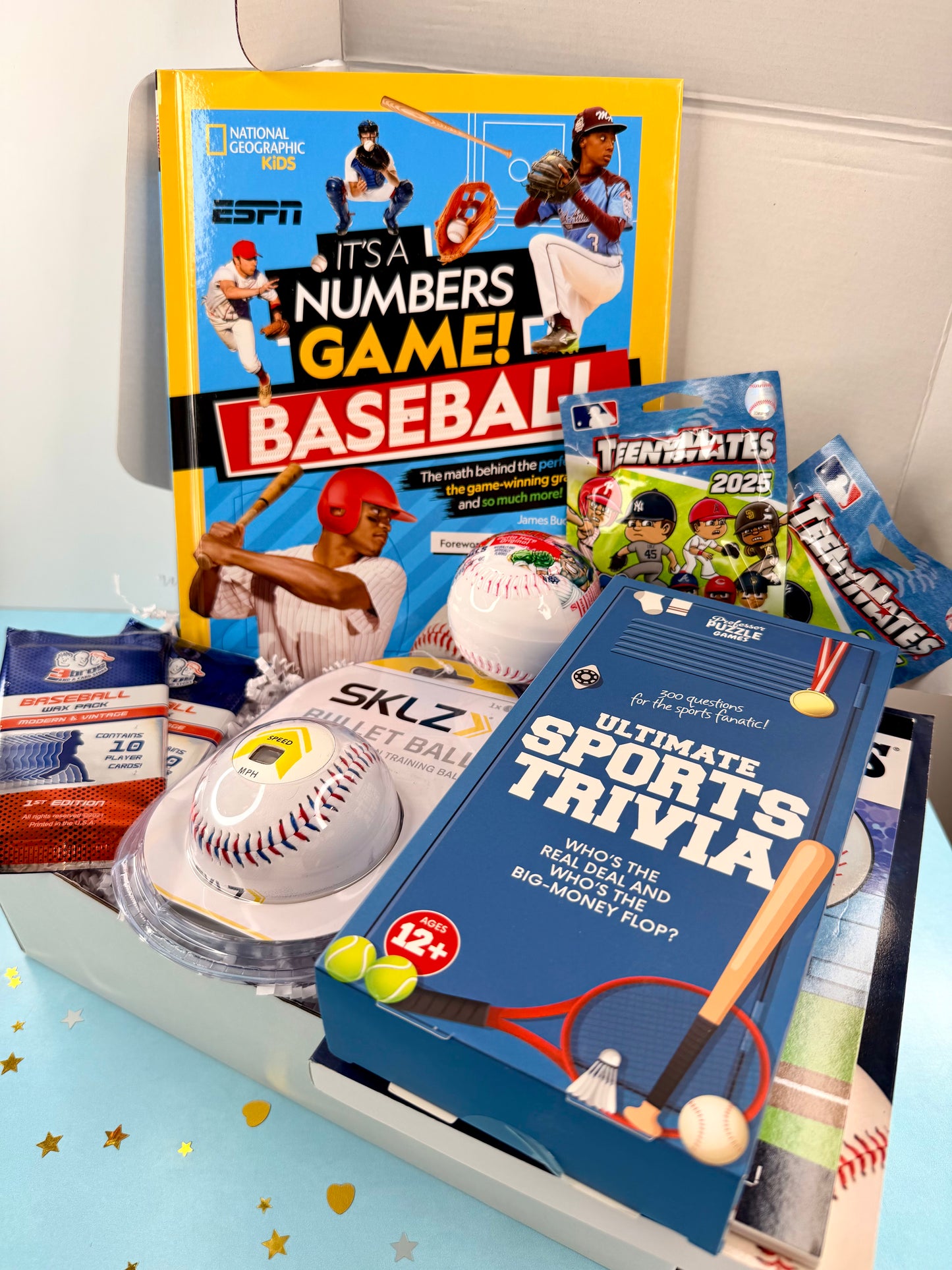 Collection of sports-themed books and toys on a light blue surface with a white background