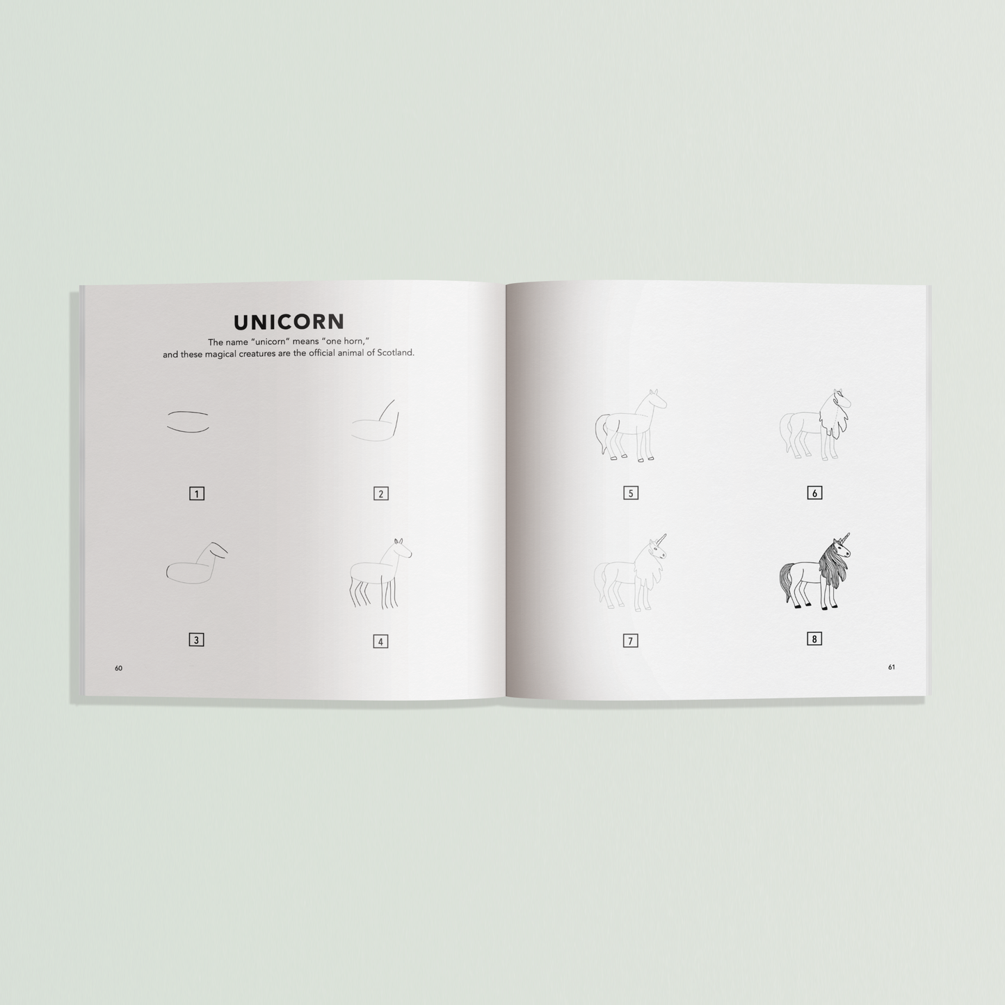 Open book showing illustrations of a unicorn on a light gray background