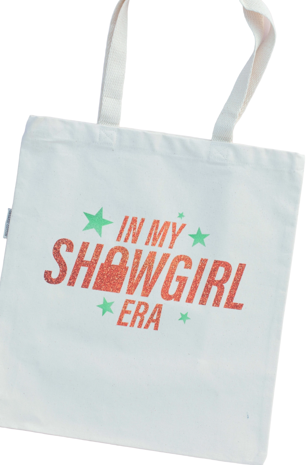 Light blue tote bag with 'In My Showgirl Era' text and stars on a white background