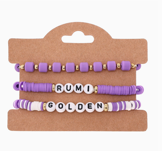 Set of purple and gold beaded bracelets on a cardboard display with 'RUMI' and 'GOLDEN' text.