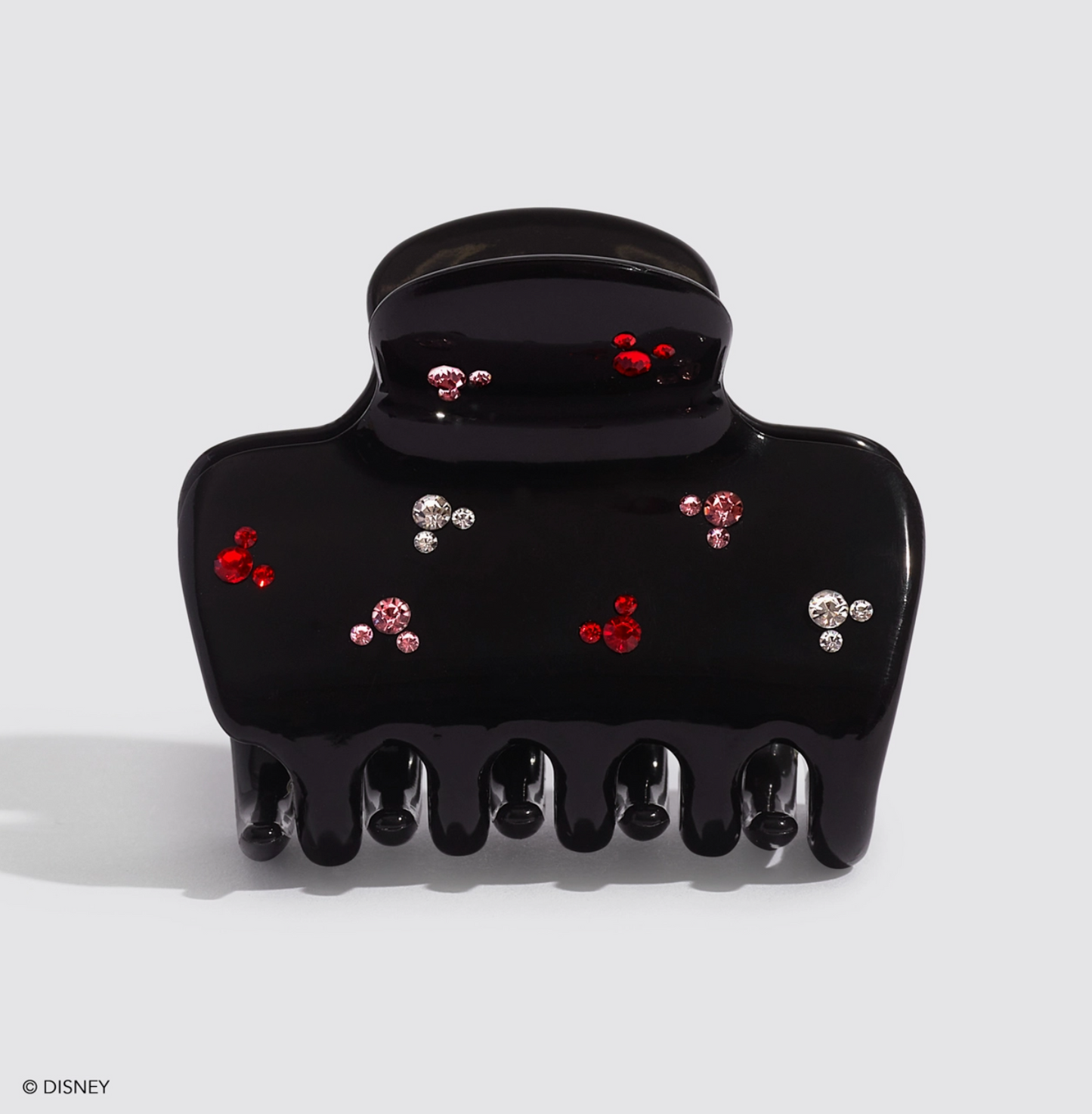 Black hair clip with decorative gems on a white background