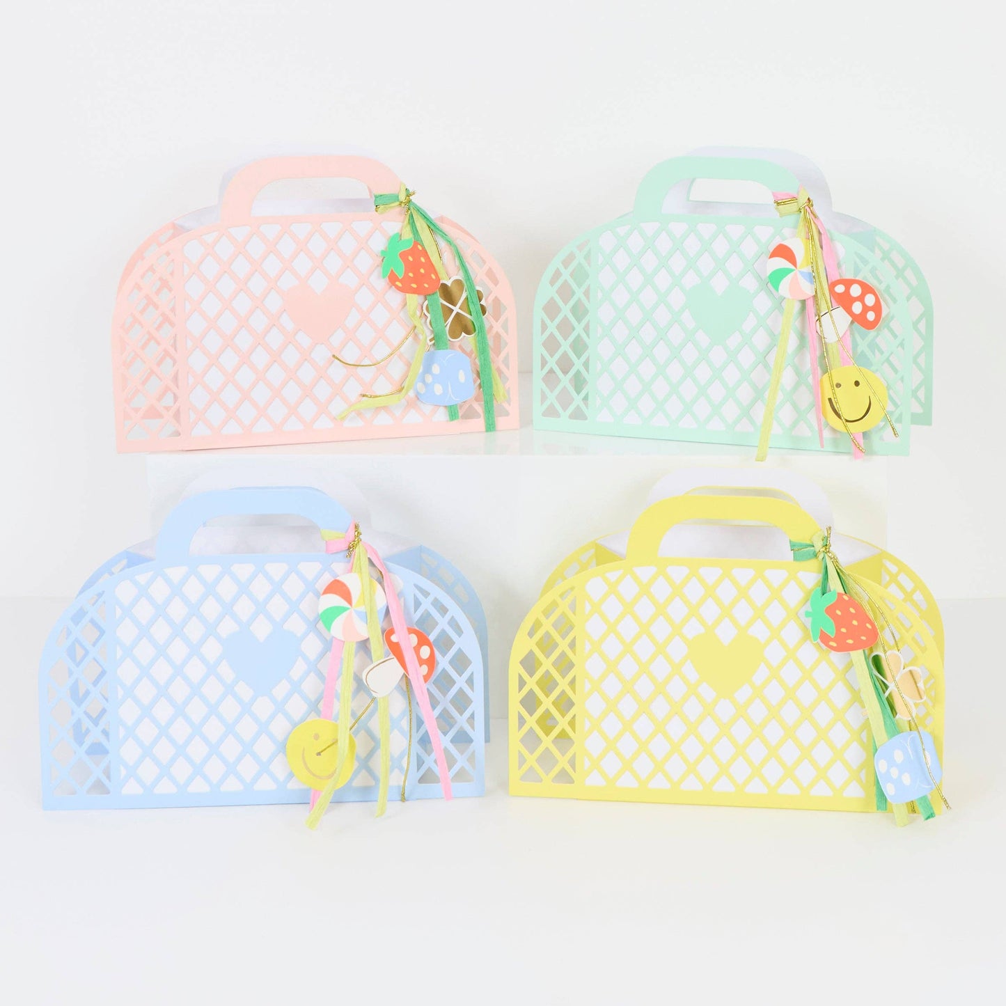 Four colorful mesh bags with decorative handles on a white background