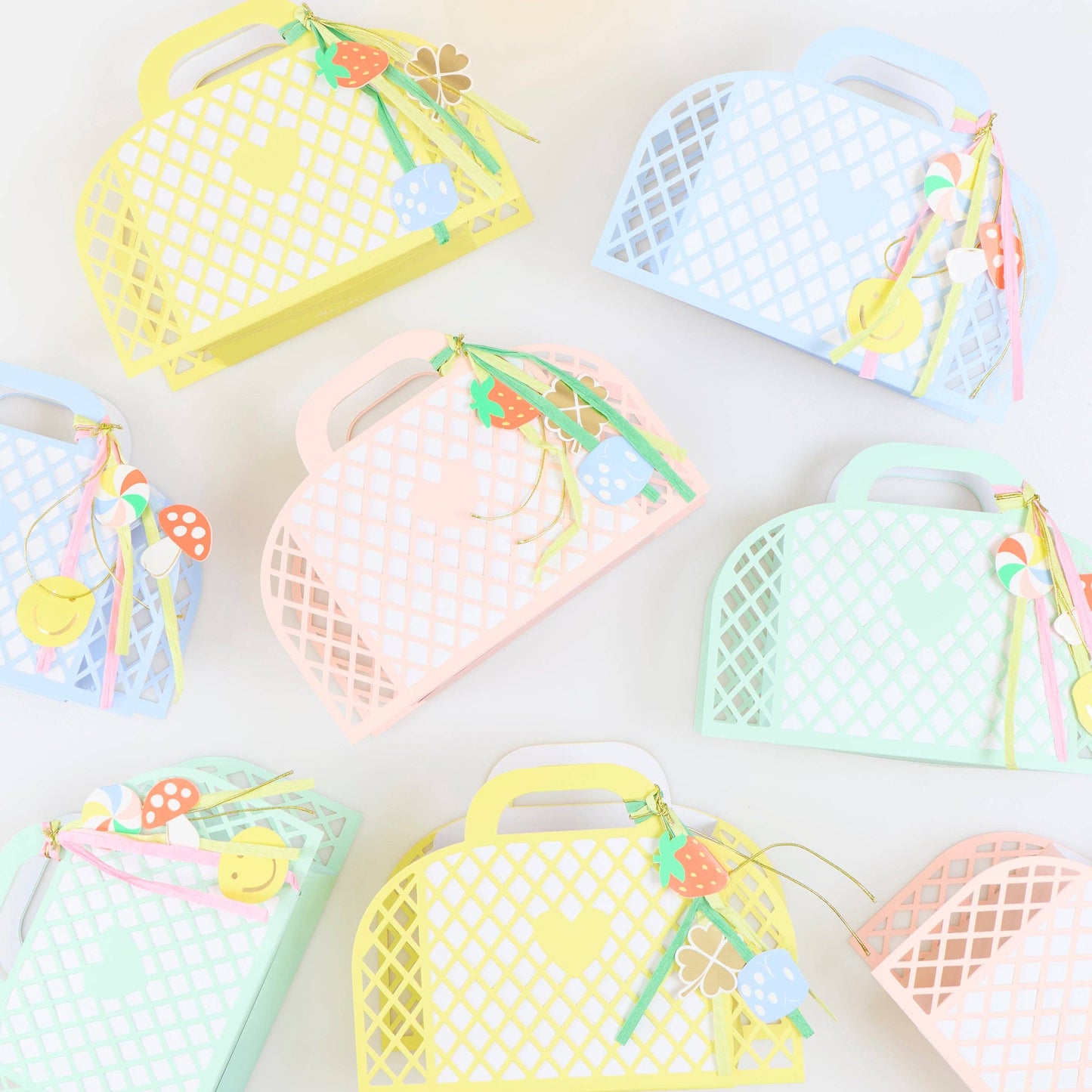 Colorful mesh bags with handles and decorative elements on a light background