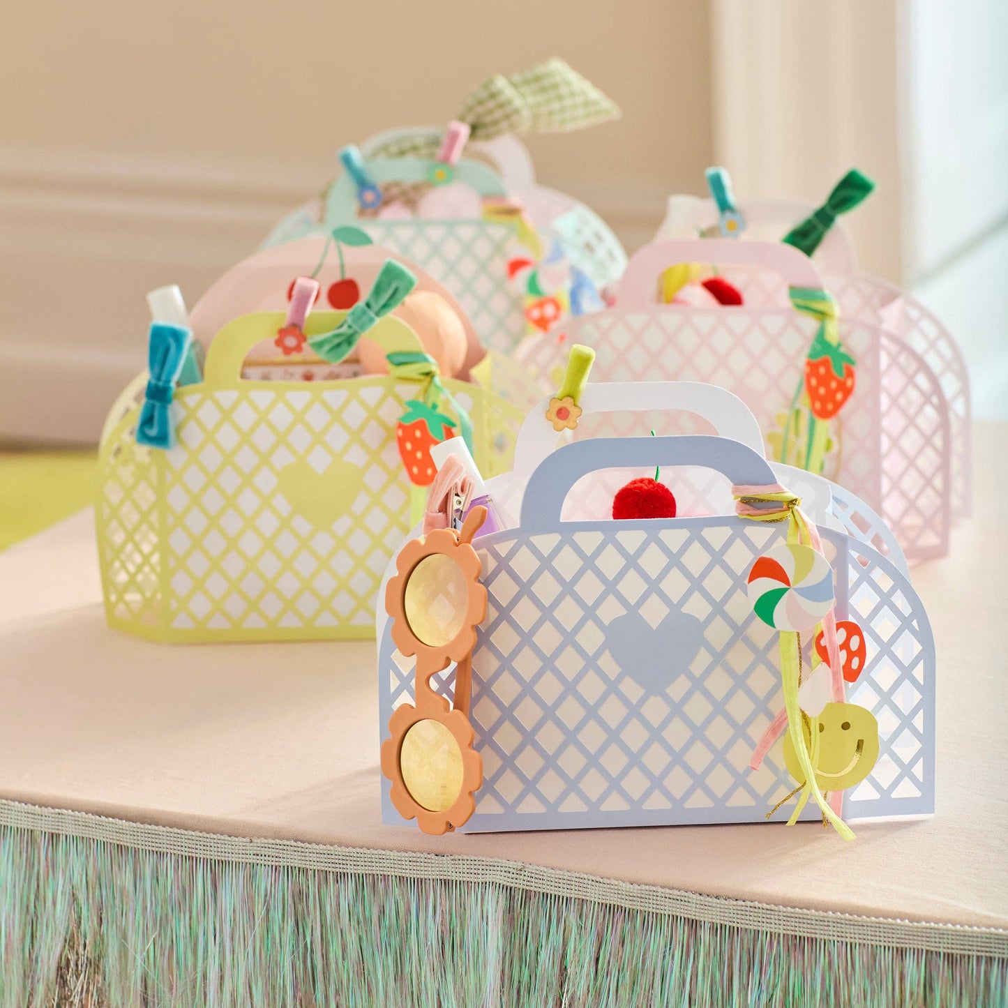 Colorful paper craft bags with decorative elements on a wooden surface.