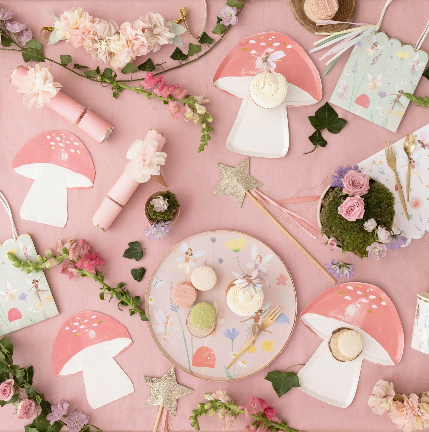 Pastel-colored party supplies including mushrooms, flowers, and plates on a pink background