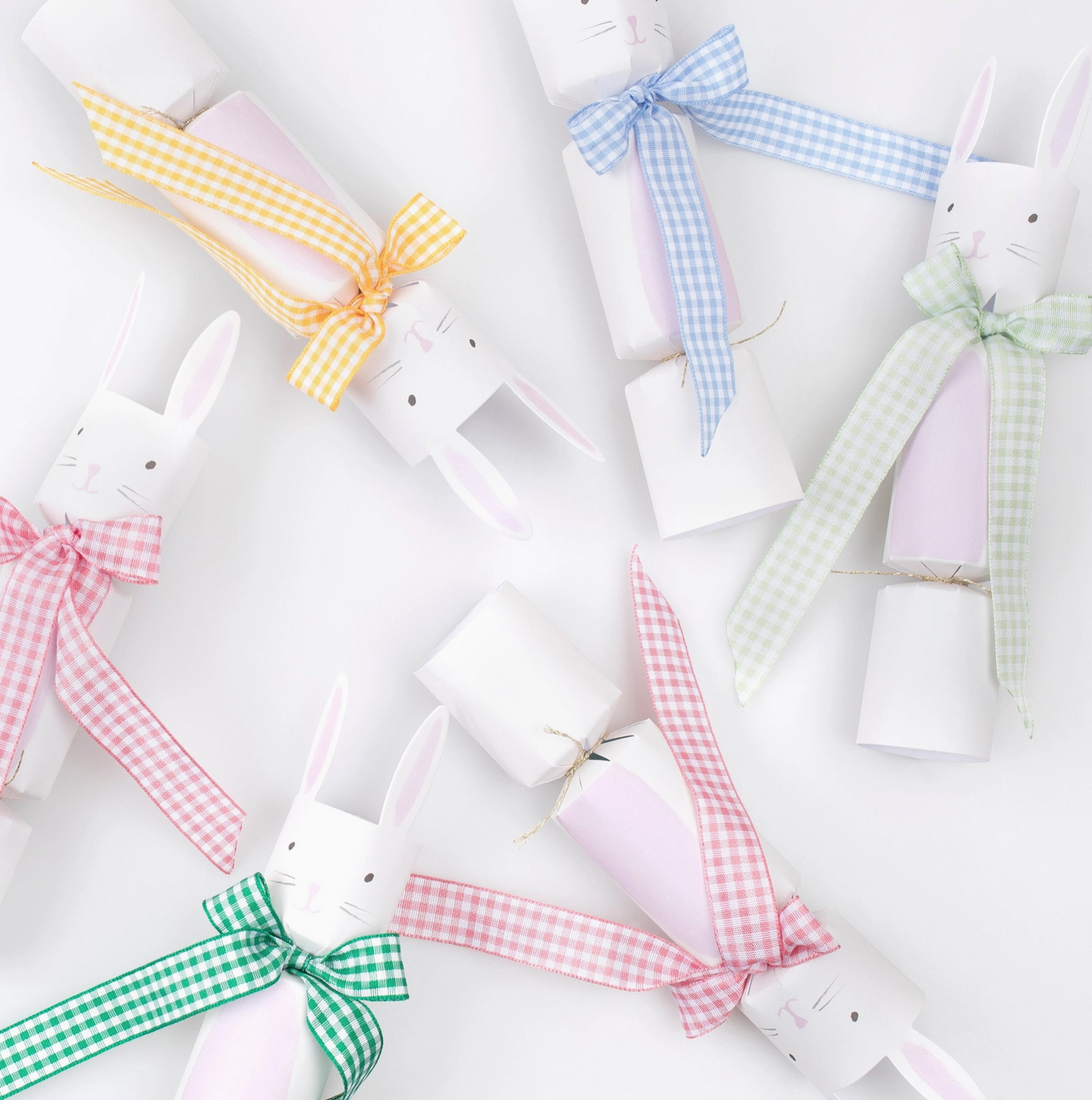 White plush toys with colorful gingham bows on a white background