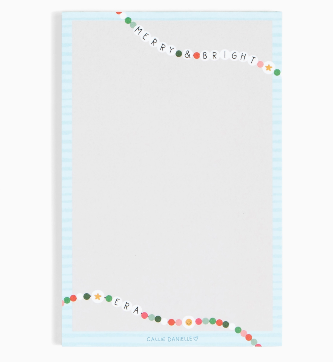 Notepad with 'Merry & Bright' text and colorful border on a light blue background