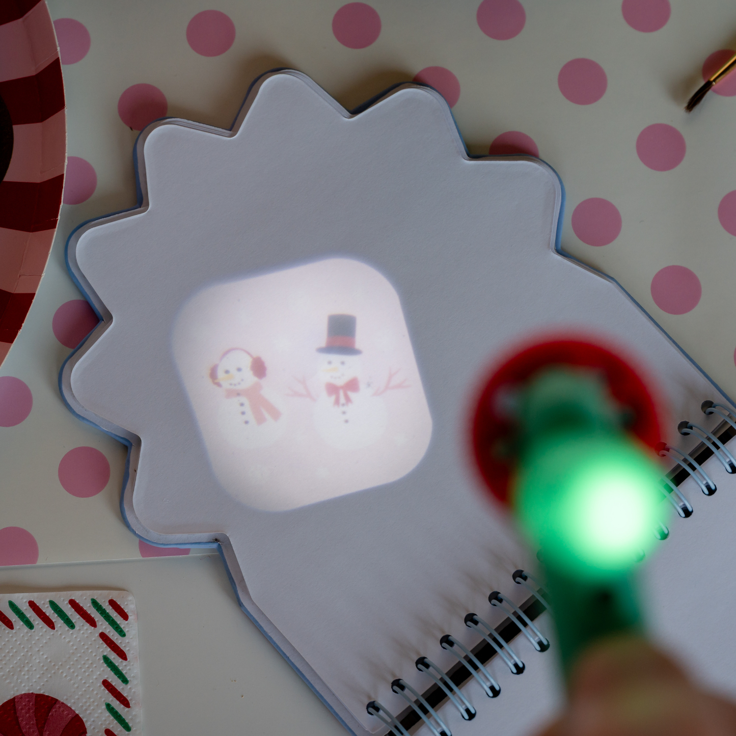 Notebook with a lion design on a polka dot background, illuminated by a green light.