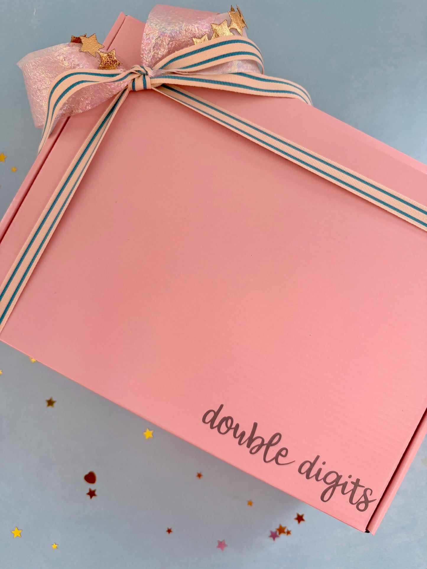 Pink gift box with a bow labeled 'double digits' on a light blue background