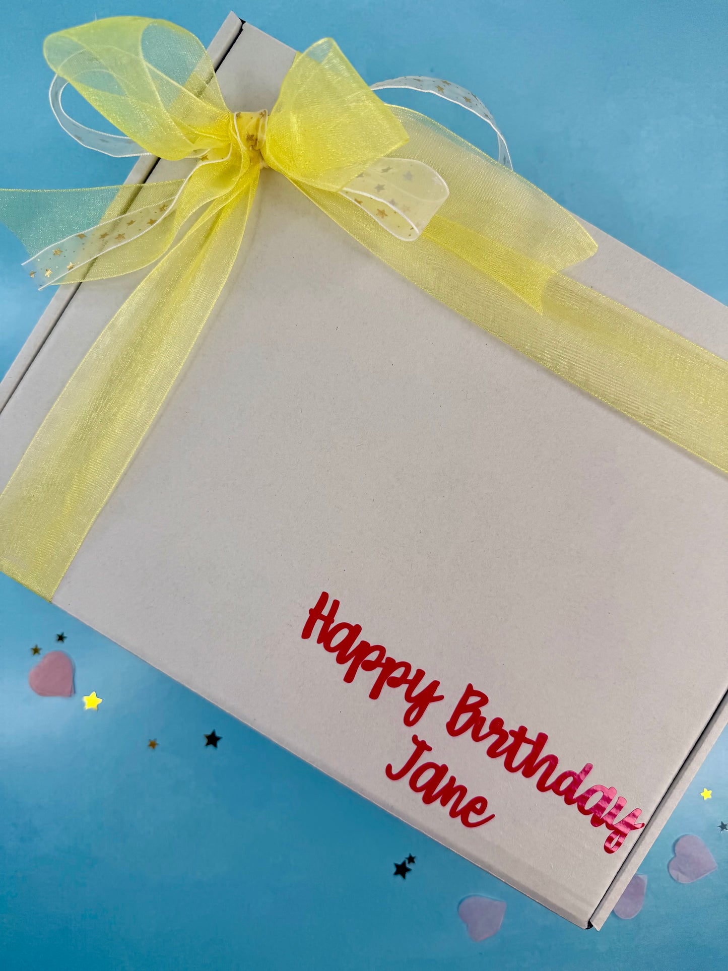 Gift box with a yellow ribbon and 'Happy Birthday Jane' text on a blue background
