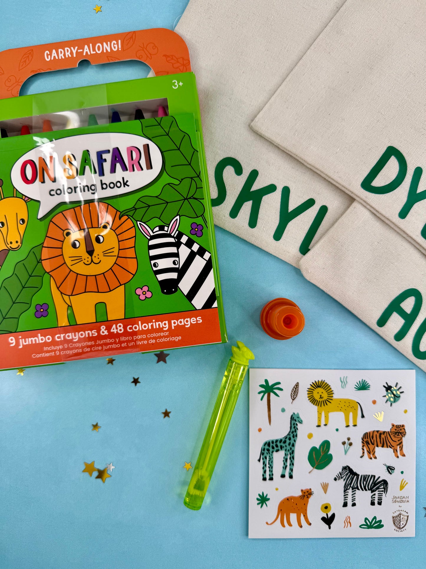 On Safari coloring book with crayons and stickers on a blue surface