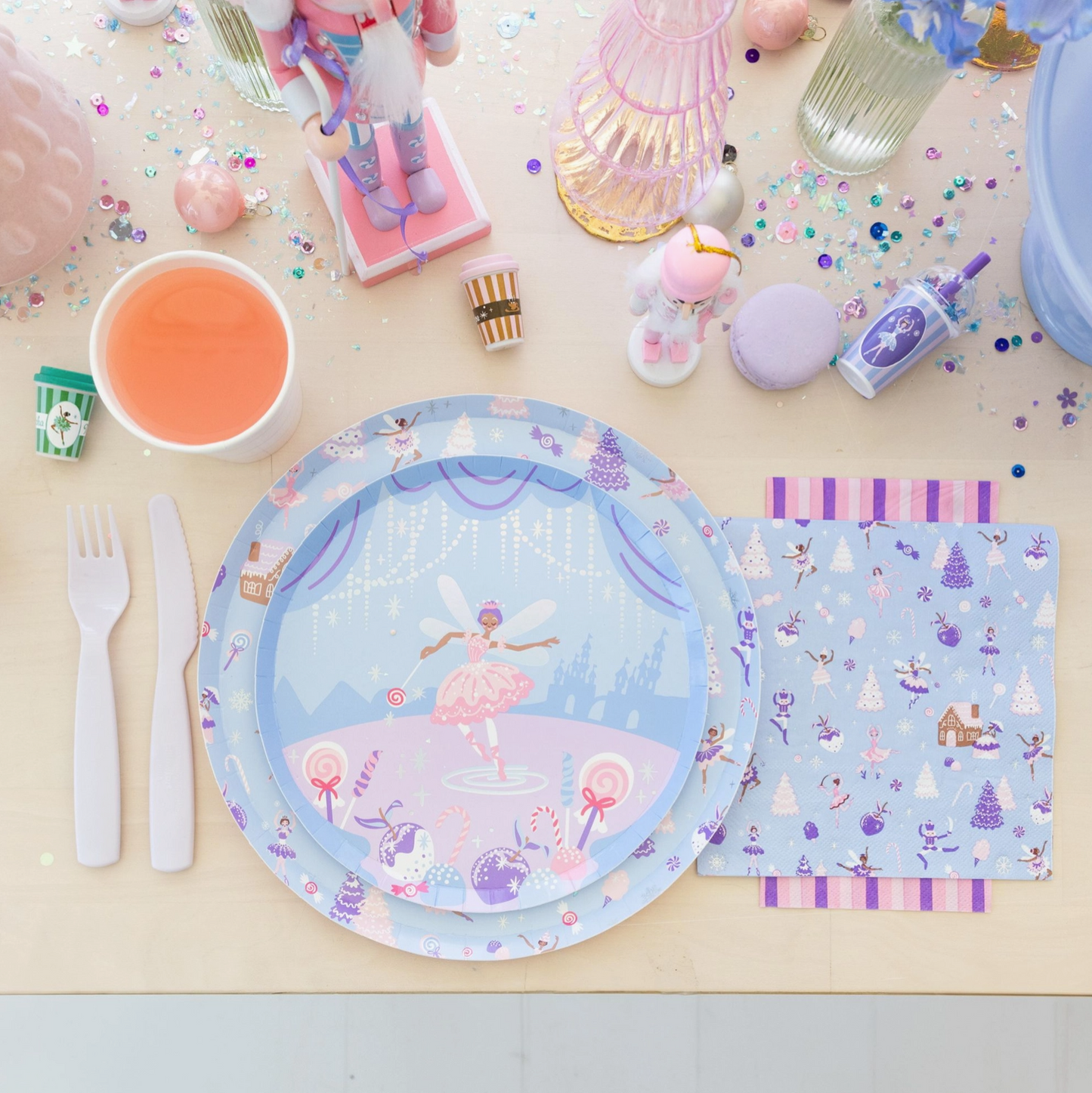 Pastel-colored tableware set with a fairy design on a light surface.