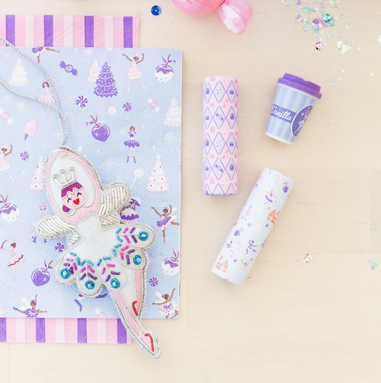 Pastel-colored stationery items including a notebook, pen, and cup on a beige background.