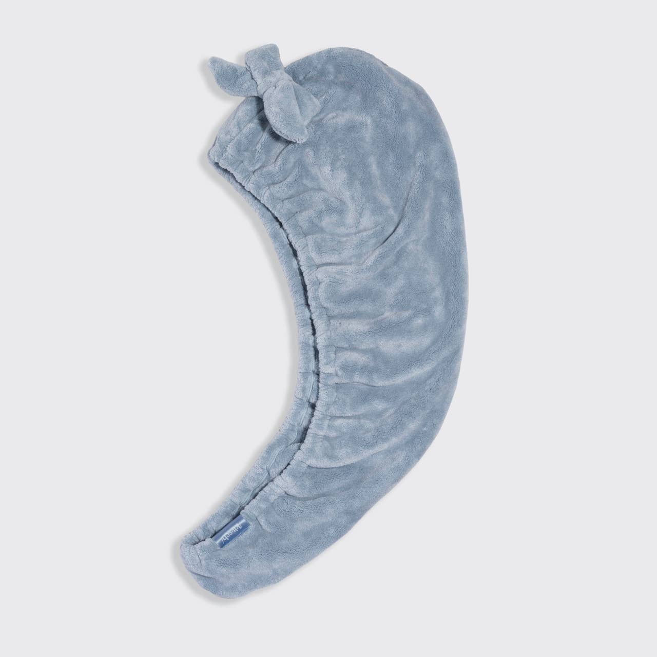 Blue plush headband with a bow on a light gray background