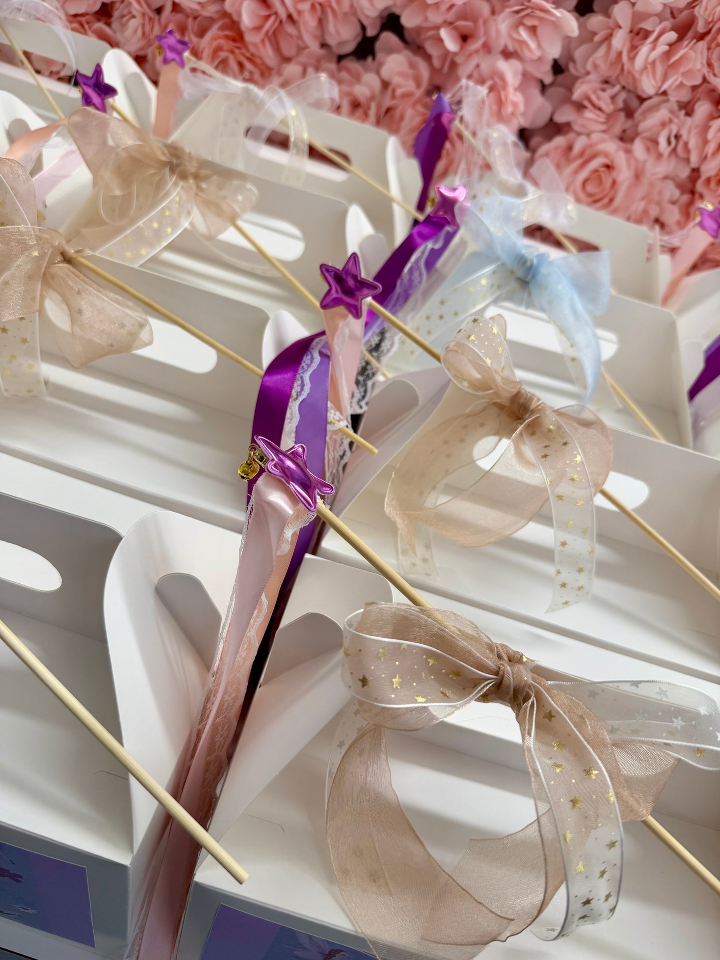 Decorative items with ribbons and bows on a white surface against a floral background