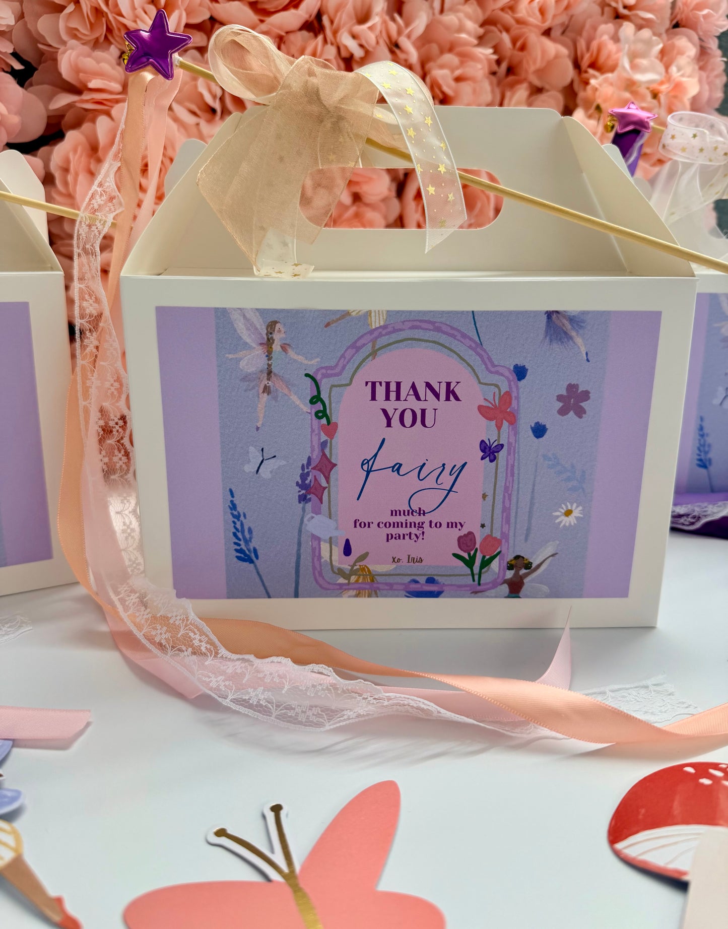 Gift box with fairy-themed design and pink ribbon on a floral background