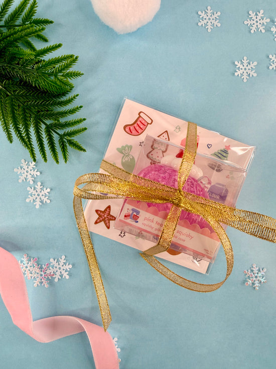 Gift card with a gold ribbon on a blue background with snowflakes and greenery