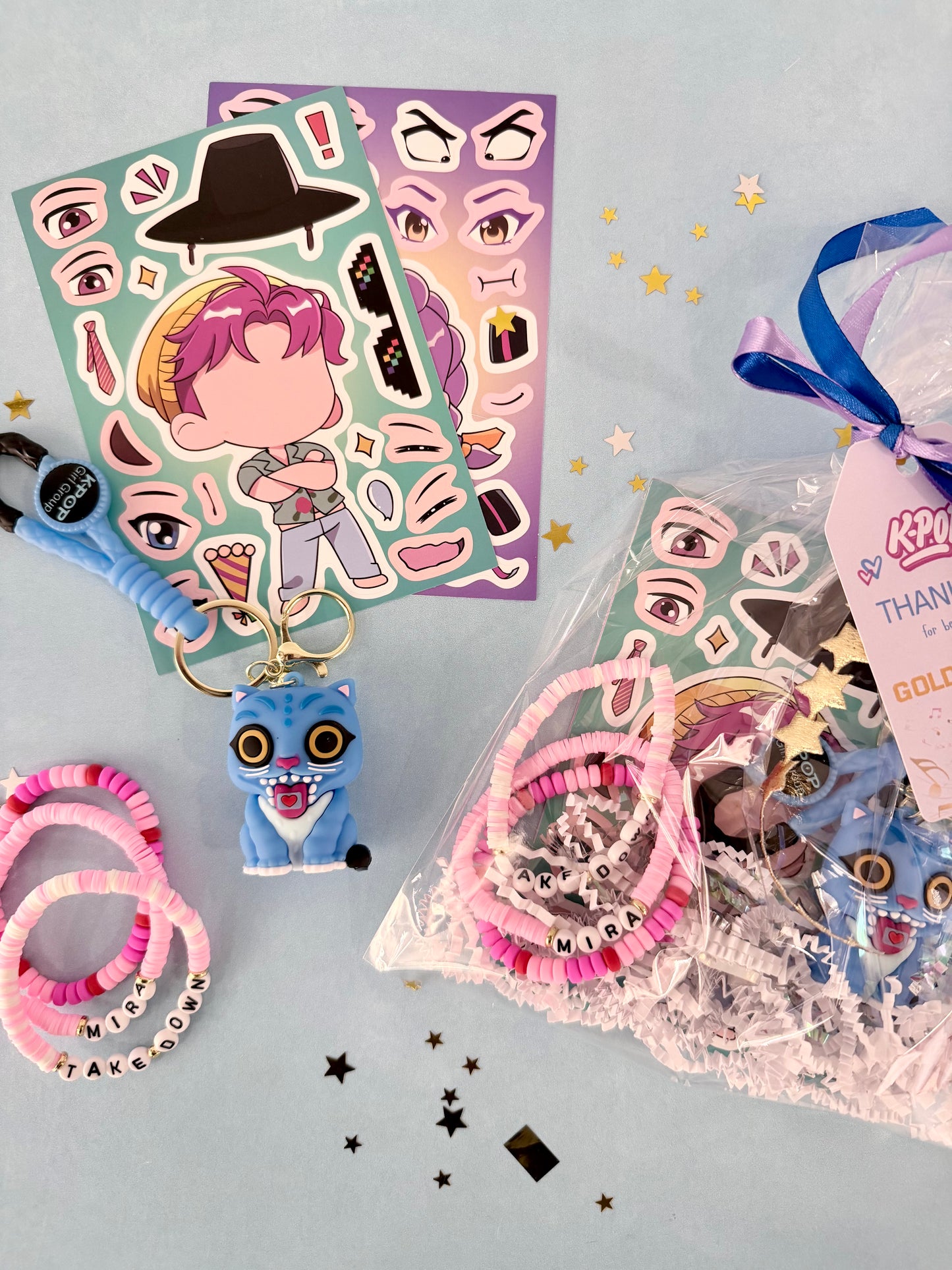 Sticker sheets and keychain with character design on a light blue background