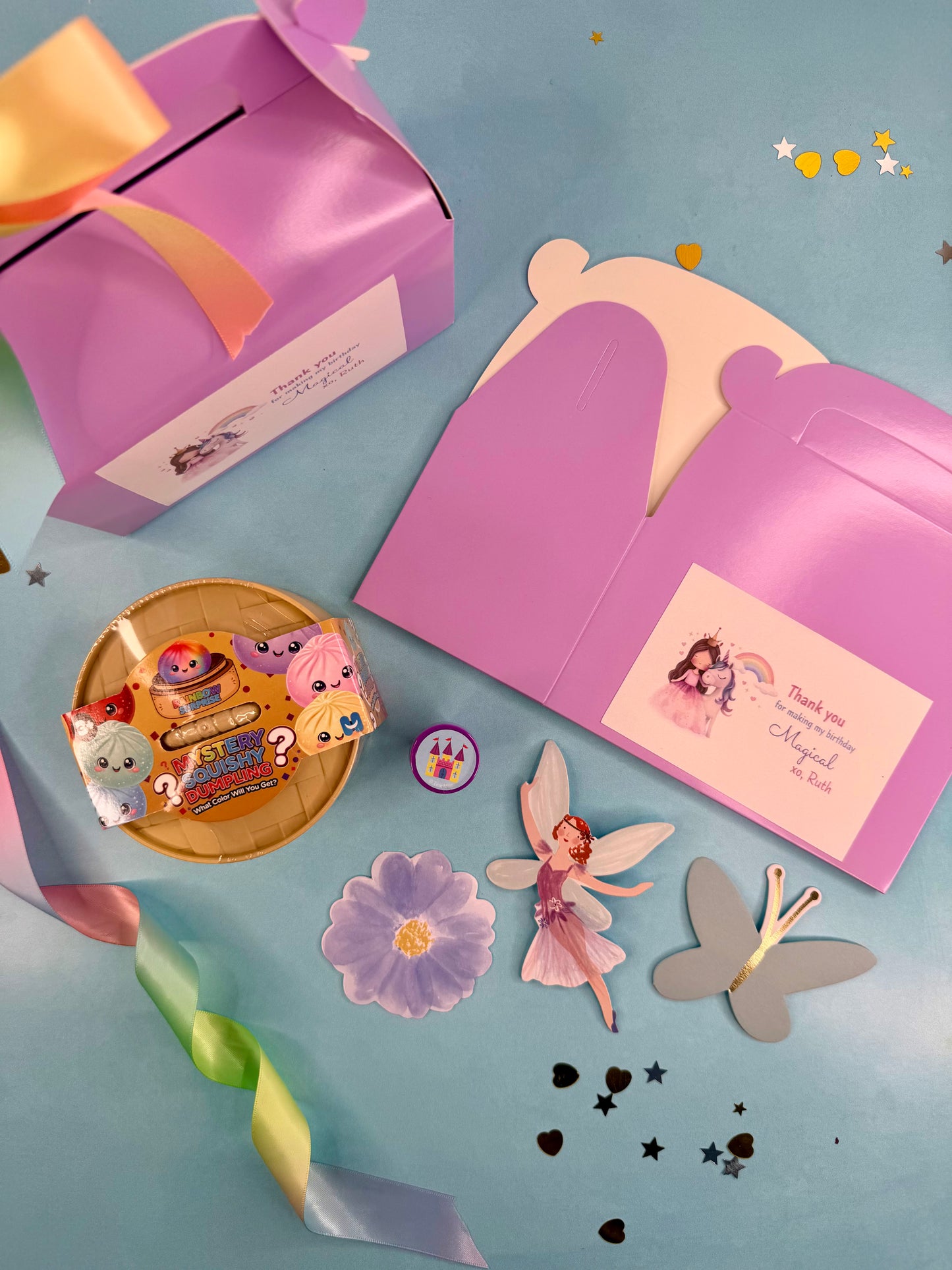 Children's party favor set with purple castle, fairy decorations, and party supplies on a blue background.