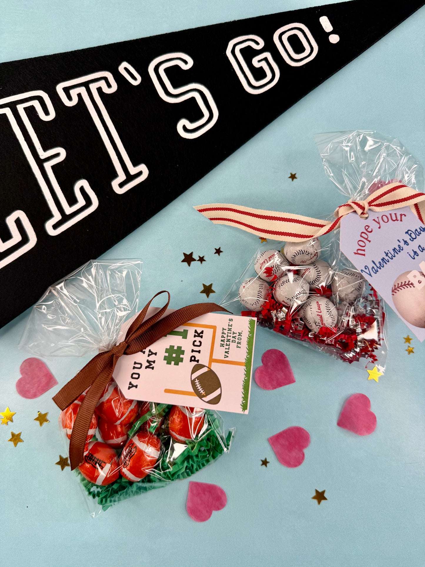Valentine's Day treats in clear bags with ribbons and tags on a light blue background with 'Let's Go!' banner.
