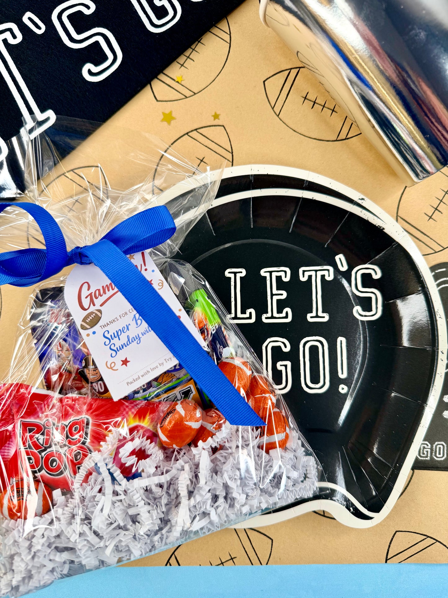 Gift basket with candy and a 'Let's Go!' plate on a sports-themed background