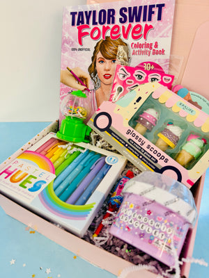 Coloring book, stationery items, and toy set in a box with Taylor Swift coloring book on top.